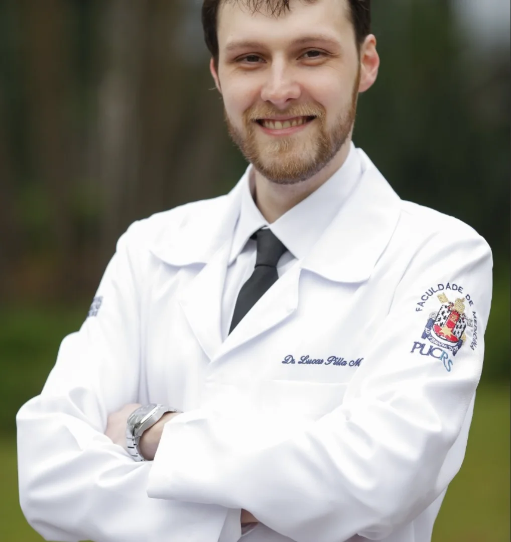 Dr. Lucas Müzell sorrindo, de jaleco branco