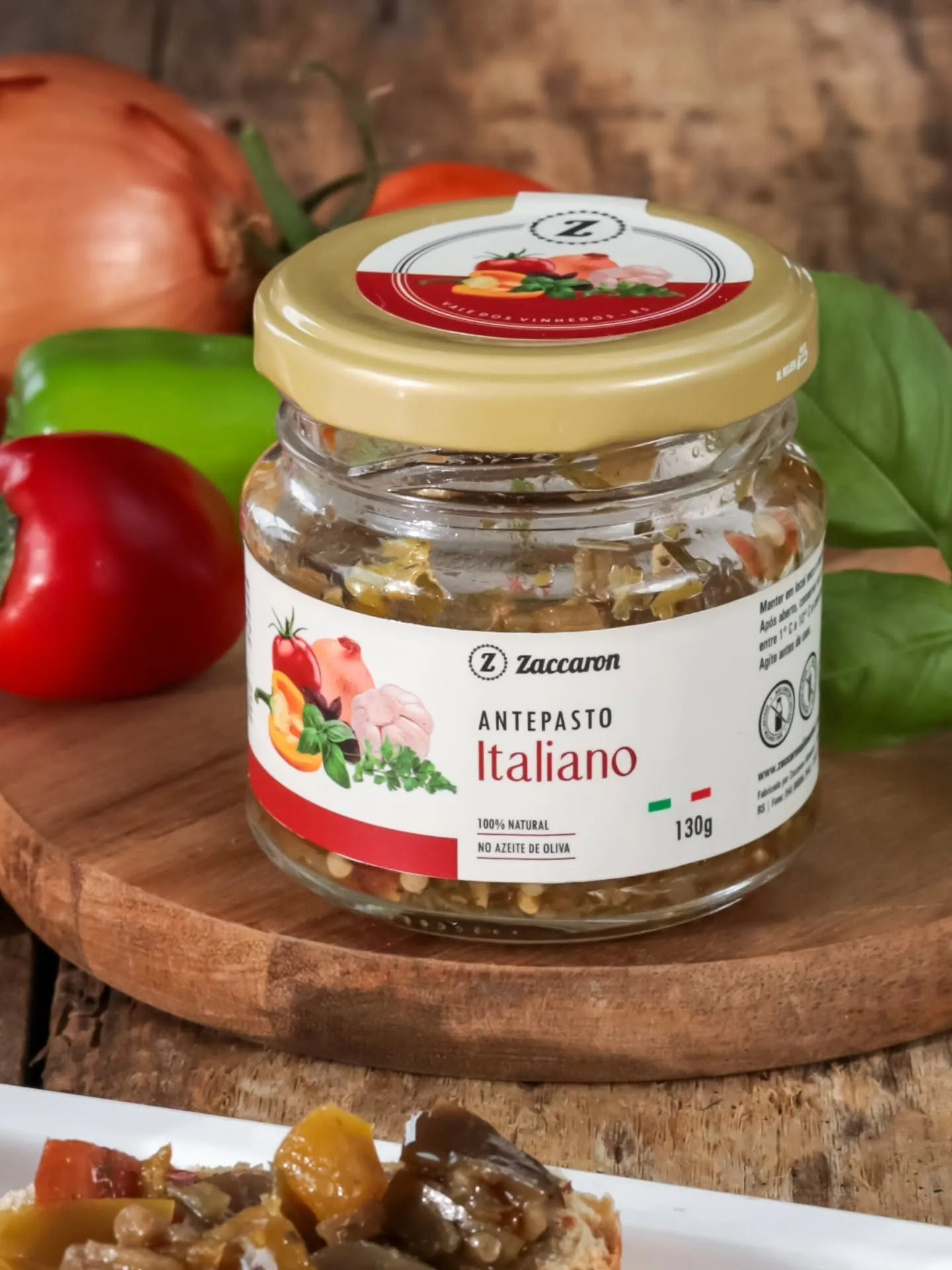 Pote de Antepasto Italiano Zaccaron sobre tábua de madeira com pimentões